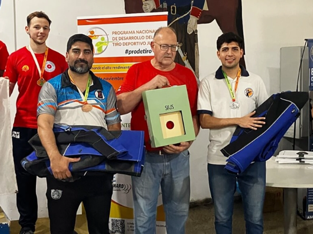 El Señor Raúl Antonio Mattig, Presidente del TFA Suizo San Carlos, con el blanco electrónico ganada por sus deportistas, acompañado de los instructores de Tierra del Fuego y La Rioja destinatarios de su hermoso gesto final.